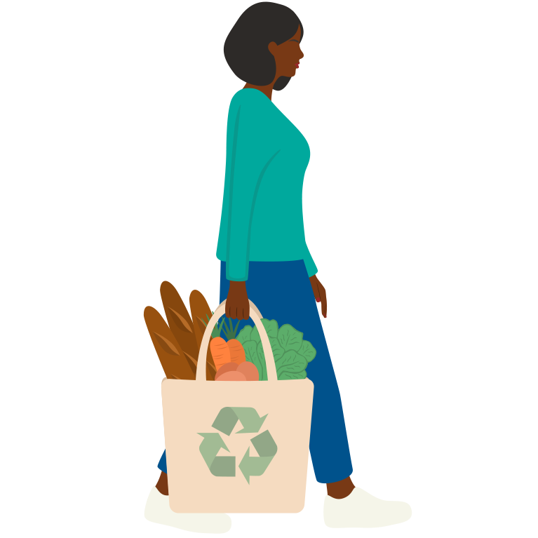 A person walking while carrying a reusable bag containing vegetables and bread